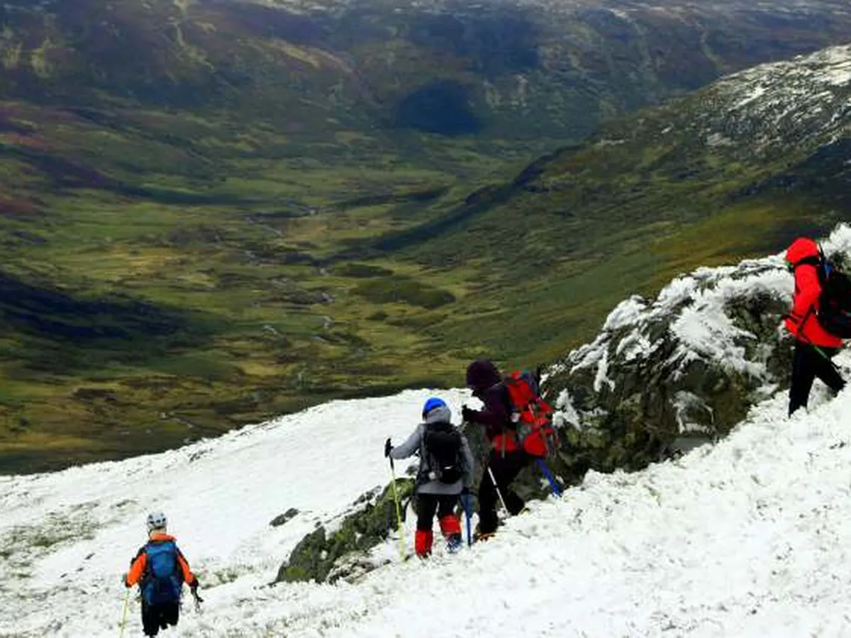 Grupo de montañeros ascendiendo una ladera nevada en el entorno de Majadavieja