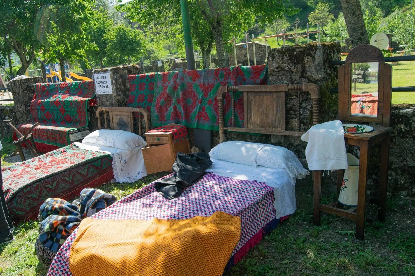 Exposición al aire libre de camas con colchas y ajuar tradicional en Porto