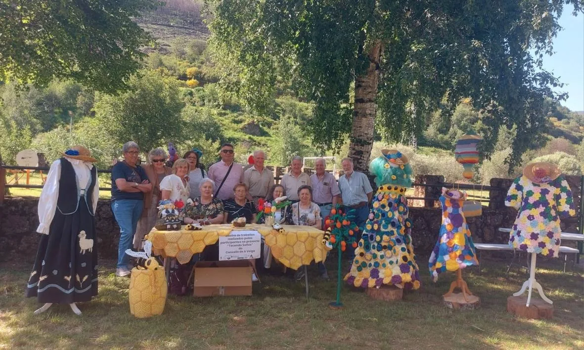 Participantes junto a la exposición de trabajos de ganchillo