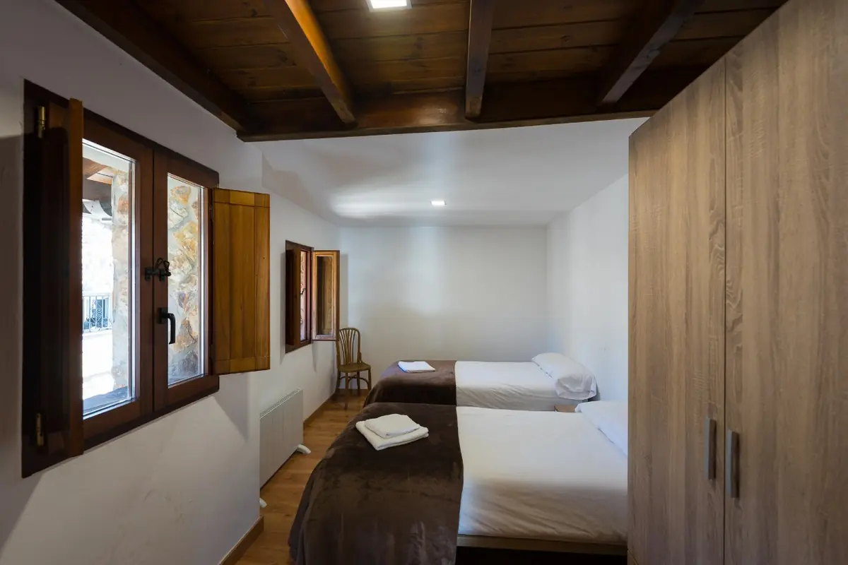 Dormitorio con dos camas y armario de madera de la Casa Acebral