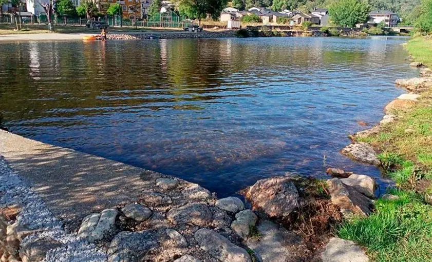 Playa fluvial del río Bibey con aguas tranquilas y orilla de piedra