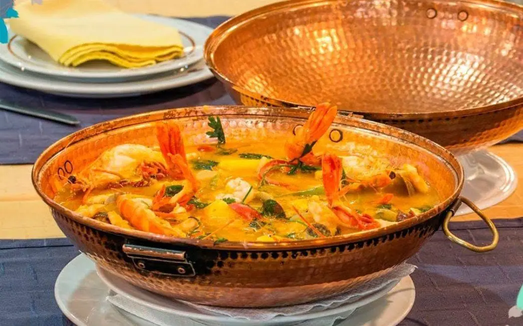 Caldeirada de marisco servida en cazuela de cobre