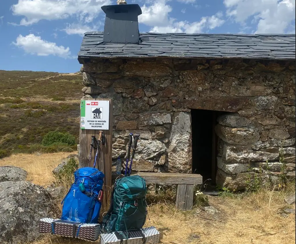 Mochilas de montaña a la entrada de un refugio de piedra