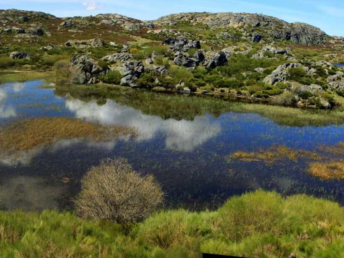 Senderista contemplando la Laguna de Lacillo desde un roquedo