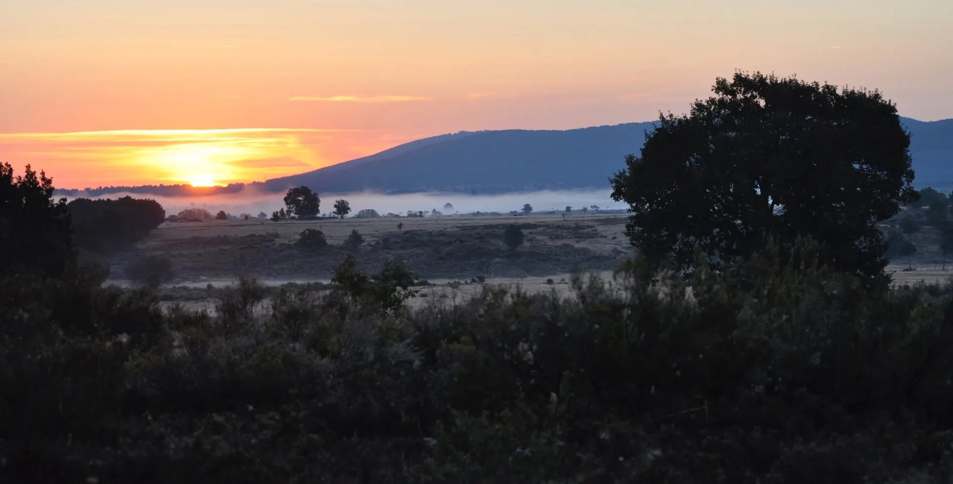 Atardecer sobre la sierra con niebla en el valle