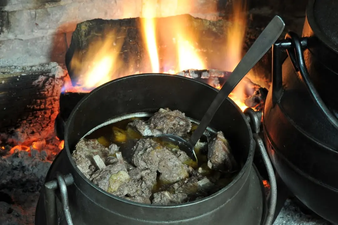 Pote de hierro al fuego en una lareira